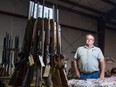 Ernie Gazdewich, a firearms vendor, stands at his display at a gun show being held at the curling rink in Canora, Saskatchewan.