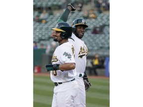 Oakland Athletics shortstop Jurickson Profar, right, is congratulated by teammate Marcus Semien (10) after hitting a two-run home run against Cincinnati Reds pitcher Sonny Gray during the first inning of a baseball game, Wednesday, May 8, 2019, in Oakland, Calif.