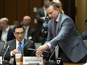 Facebook's Global Director and Head of Public Policy, Canada Kevin Chan, left, reacts as the clerk places a name plate for Facebook's Mark Zuckerberg at The International Grand Committee on Big Data, Privacy and Democracy in Ottawa, Tuesday May 28, 2019.