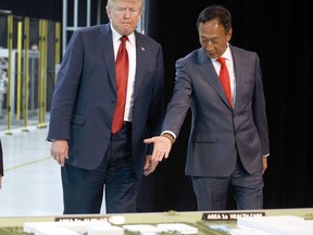 FILE - In this Thursday, June 28, 2018, file photo, President Donald Trump, left, takes a tour of Foxconn with Foxconn chairman Terry Gou in Mt. Pleasant, Wis. Gou says the Taiwanese company is moving forward with its plan to build a manufacturing facility in Wisconsin and President Donald Trump has promised to visit when production starts next year. Gou met with Trump on Wednesday to discuss the ever-changing project. Foxconn, the world's largest electronics company whose customers include Apple, Amazon and Google, plans to build a display screen factory in southeast Wisconsin.
