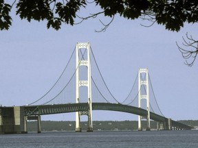 FILE - This July 19, 2002, file photo, shows the Mackinac Bridge that spans the Straits of Mackinac from Mackinaw City, Mich. Enbridge Inc. says it's setting a firm deadline for completing a proposed oil pipeline tunnel beneath a key Great Lakes channel linking Lake Huron and Lake Michigan. The Canadian company says it has pledged to Michigan Gov. Gretchen Whitmer that the tunnel under the Straits of Mackinac would be in service by early 2024. Enbridge spokesman Michael Barnes said Thursday, May 30, 2019, the company made a firm commitment to it in a recent letter to Whitmer.