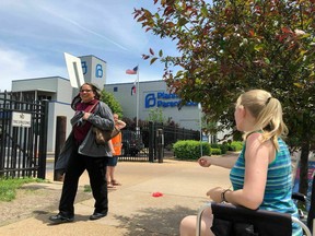 FILE - In this May 17, 2019 file photo, Teresa Pettis, right, greets a passerby outside the Planned Parenthood clinic in St. Louis. Pettis was one of a small number of abortion opponents protesting outside the clinic on the day the Missouri Legislature passed a sweeping measure banning abortions at eight weeks of pregnancy. Planned Parenthood says Missouri's only abortion clinic could be closed by the end of the week because the state is threatening to not renew its license, which expires Friday, May 31.