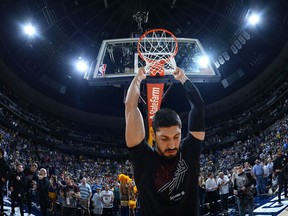 Portland Trail Blazers center Enes Kanter hangs on the net before the first half of Game 7 of an NBA basketball second-round playoff series against the Denver Nuggets Sunday, May 12, 2019, in Denver.