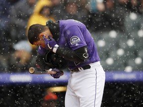 Colorado Rockies' Nolan Arenado cleans snow out of his ear while batting against the San Francisco Giants in the first inning of a baseball game Thursday, May 9, 2019, in Denver.
