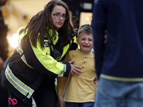 RETRANSMIT WITH ALTERNATE CROP Officials guide students off a bus and into a recreation center where they were reunited with their parents after a shooting at a suburban Denver middle school Tuesday, May 7, 2019, in Highlands Ranch, Colo.