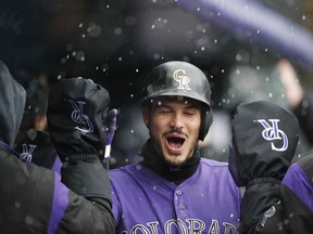 Colorado Rockies' Nolan Arenado is congratulated as he returns to the dugout after hitting a two-run home run off San Francisco Giants starting pitcher Derek Holland in the first inning of a baseball game Thursday, May 9, 2019, in Denver.