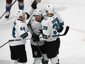 San Jose Sharks defenseman Marc-Edouard Vlasic, left, celebrates with center Gustav Nyquist and center Logan Couture, right, after his goal against the Colorado Avalanche during the third period of Game 3 of an NHL hockey second-round playoff series Tuesday, April 30, 2019, in Denver. The Sharks won 4-2.