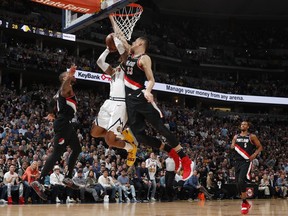 Portland Trail Blazers forward Zach Collins, front, fouls Denver Nuggets guard Gary Harris as he shoots while Portland guard Damian Lillard defends in the first half of Game 5 of an NBA basketball second-round playoff series, Tuesday, May 7, 2019, in Denver.