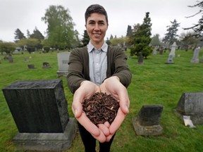 In this April 19, 2019, file photo, Katrina Spade, the founder and CEO of Recompose, a company that hopes to use composting as an alternative to burying or cremating human remains, poses for a photo in a cemetery in Seattle, as she displays a sample of compost material left from the decomposition of a cow using a combination of wood chips, alfalfa and straw.