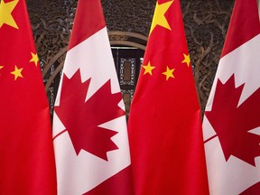 Flags of Canada and China are seen prior to a meeting of Canadian Prime Minister Justin Trudeau and Chinese President Xi Jinping at the Diaoyutai State Guesthouse in Beijing on Dec. 5, 2017. China has formally arrested two Canadian citizens it's been holding since December in an apparent effort to pressure Canada into releasing a Chinese telecom executive.