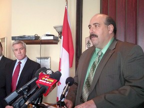 N.L. Progressive Conservative member of parliament Paul Lane announces his defection to the Liberal party in Mount Pearl, N.L. on Jan. 20, 2014, as Liberal Leader Dwight Ball looks on.