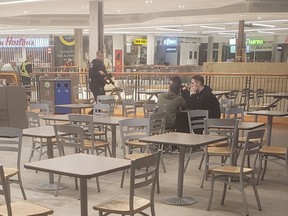 A police officer with his weapon drawn walks in a food court in a mall in St.John's, Friday, May 10, 2019. A young woman who witnessed a police officer walking through a St. John's mall with a carbine firearm at the ready says she wishes officers could tell citizens more when highly armed situations arise in public venues.