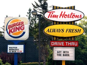 Burger King and Tim Hortons signs are displayed on St. Laurent Boulevard in Ottawa on Monday, August 25, 2014. Restaurant Brands International Inc. says it plans to grow to more than 40,000 restaurants around the world over the next eight to 10 years.