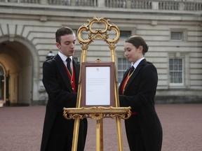 Footmen Stephen Kelly and Sarah Thompson bring out the easel in the forecourt of Buckingham Palace to formally announce the birth of a baby boy to Britain's Prince Harry and Meghan, the Duchess of Sussex, in London, Monday, May 6, 2019.