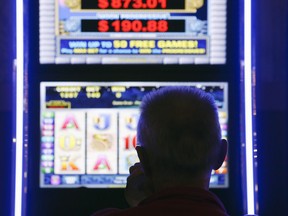 A man plays at a video lottery terminal at Tioga Downs, in Nichols, N.Y., on October 16, 2014. The Supreme Court of Canada will look at whether a potentially groundbreaking court case that takes aim at video-lottery terminals can proceed and, if so, on what grounds. The high court has agreed to jointly hear two challenges flowing from a decision of the Newfoundland and Labrador Court of Appeal that cleared the way for a class action alleging VLTs are inherently deceptive, addictive and illegal under the Criminal Code.