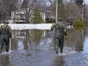 Two soldiers walk down a street in a flooded neighbourhood in Rigaud, Que. on Monday, April 29, 2019. Water levels are expected to rise again this weekend between Ottawa and Montreal, even as New Brunswick's floods are effectively over.