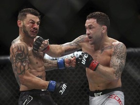 Frankie Edgar, right, hits Cub Swanson during the third round of their UFBC mixed martial arts featherweight bout early Sunday, April 22, 2018, in Atlantic City, N.J. Edgar won the bout.