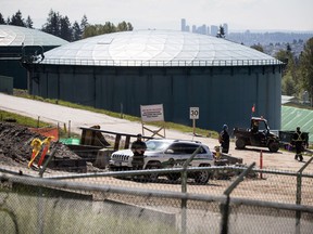 A security guard stands nearby as construction workers at the Kinder Morgan Burnaby Terminal tank farm, the terminus point of the Trans Mountain pipeline, in Burnaby, B.C., on April 30, 2019. A British Columbia court is set to rule whether the province can restrict shipments of diluted bitumen through its borders, in a crucial decision for the future of the Trans Mountain pipeline expansion. The province filed a reference case to the B.C. Court of Appeal that asked whether it had the authority to create a permitting regime for companies that wished to increase their flow of oilsands crude.