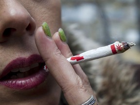 A woman smokes a marijuana joint at a legalized marijuana event in Toronto on Wednesday, October 17, 2018. A new survey suggests Canadians have become less accepting of recreational cannabis since legalization two years ago.