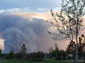 Smoke column can be seen from the Town of High Level, the evening of Tuesday May 21, 2019. The mayor of a northwestern Alberta town says the threat from a powerful wildfire burning three kilometres away has not passed and warns evacuees they could be out longer than expected.