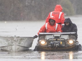 Members of the Surete du Quebec evacuate a man from his home in Rigaud, Que. west of Montreal, Friday, April 26, 2019. Montreal first responders are warning against so-called disaster tourism after noting a spike in selfie-seekers in neighbourhoods threatened by swollen rivers.