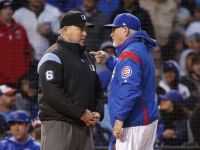 Chicago Cubs manager Joe Maddon, right, argues a call against his team with umpire Mark Carlson, left, during the fourth inning of a baseball game, Tuesday, May 21, 2019, in Chicago.