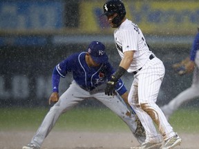 Chicago White Sox's Yolmer Sanchez, right, is safe at second base as Kansas City Royals' Nicky Lopez drops the ball during the fifth inning of a baseball game in the rain Monday, May 27, 2019, in Chicago.