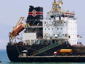 In this April 16, 2019 photo, a ship fills up on fuel from a tanker truck on the Thor terminal in Carrefour, a district of Port-au-Prince Haiti. Through the Venezuelan aid program known as Petrocaribe, more than half the costs of the oil given to Haiti, which came at a heavily discounted price, were repayable over 25 years at a 1% interest rate, allowing the central government to supposedly use the windfall for economic development. (AP Photo/Dieu Nalio Chery)