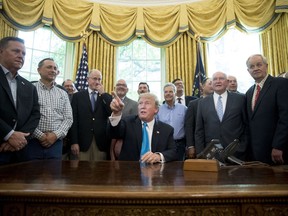President Donald Trump, accompanied by Rep. Mike Conaway, R-Texas, fourth from left, Agriculture Secretary Sonny Perdue, fourth from right, and farmers and ranchers, speaks in the Oval Office of the White House, Thursday, May 23, 2019, in Washington.