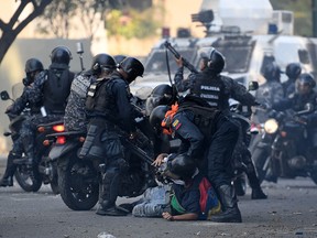 An anti-government protester is detained by security forces in Caracas on May 1, 2019.