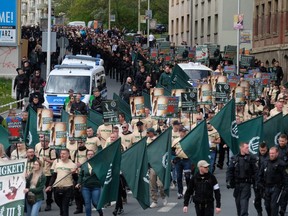 Protestors march with flags during a demonstration of the far-right party 'The third way' in Plauen, Germany, Wednesday, May 1, 2019.