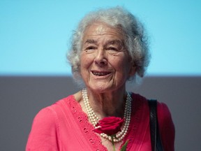 FILE - In this Sept. 15, 2016 file photo British writer Judith Kerr holds a rose in Berlin, Germany. Judith Kerr, author and illustrator of the bestselling "The Tiger Who Came to Tea" and other beloved children's books, has died at the age of 95.