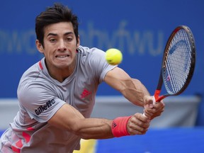 Cristian Garin of Chile returns the ball to Marco Cecchinato of Italy during their semifinal match at the ATP tennis tournament in Munich, Germany, Saturday, May 4, 2019.