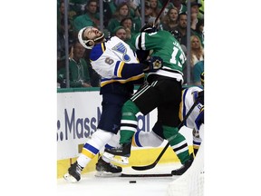 St. Louis Blues' Joel Edmundson (6) recoils after being hit by Dallas Stars' Mattias Janmark, of Sweden, while fighting for control of a loose puck along the boards during the first period in Game 6 of an NHL second-round hockey playoff series, Sunday, May 5, 2019, in Dallas.