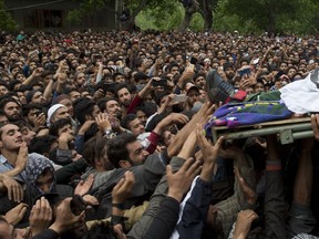 Kashmiri villagers try to touch the feet of top rebel commander Naseer Pandith, during his funeral procession in Pulwama, south of Srinagar, Indian controlled Kashmir, Thursday, May 16, 2019. Three rebels, an army soldier and a civilian were killed early Thursday during a gunbattle in disputed Kashmir that triggered anti-India protests and clashes, officials and residents said.