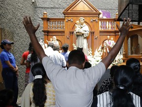 Catholic devotees pray at the St. Anthony's church after it was partially opened for the first time since Easter Sunday attacks, in Colombo, Sri Lanka, Tuesday, May 7, 2019. Two bomb experts were among the suicide attackers who struck churches and hotels on Easter in Sri Lanka and all those directly involved in the bombings are either dead or under arrest, police said.