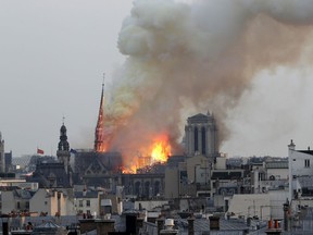 FILE. In this April 15, 2019 file photo, flames rise from Notre Dame cathedral as it burns in Paris. Notre Dame Cathedral's melted roof has left astronomically high lead levels in the plaza outside and adjacent roads. Paris police say lead levels from the roof were found to be between 10 and 20 grams per kilogram of ground -- between 32 and 65 times the recommended limit by French health authorities of 0.3 grams per kilogram.