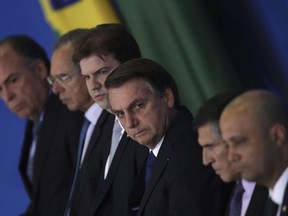 Brazil's President Jair Bolsonaro, center, accompanied by his ministers, attends a ceremony to sign a decree on Regional Development, at the Planalto Presidential Palace, in Brasilia, Brazil, Thursday, May 30, 2019.