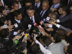 Brazil's President Jair Bolsonaro speaks to the press after signing a second decree that eases gun restrictions, at the Planalto presidential palace in Brasilia, Brazil, Tuesday, May 7, 2019. The decree opens Brazil's market to guns and ammunition made outside of Brazil according to a summary of the decree. Gun owners can now buy between 1,000 -5,000 rounds of ammunition per year depending on their license, up from 50 rounds. Lower-ranking military members can now carry guns after 10 years of service.