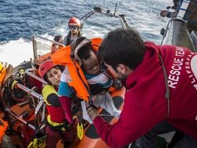 FILE - In this Friday, Dec. 21, 2018 file photo, a baby is loaded into the rescue vessel of the Spanish NGO Proactiva Open Arms, after being rescued in the Central Mediterranean Sea at 45 miles (72 kilometers) from Al Khums, Libya