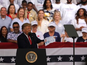 President Trump holds a chart as he speaks at a rally in Panama City Beach, Fla., Wednesday, May 8, 2019.