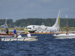 A charter plane carrying 143 people and traveling from Cuba to north Florida sits in a river at the end of a runway, Saturday, May 4, 2019 in Jacksonville, Fla.  The Boeing 737 arriving at Naval Air Station Jacksonville from Naval Station Guantanamo Bay, Cuba, with 136 passengers and seven aircrew slid off the runway Friday night into the St. Johns River, a NAS Jacksonville news release said.
