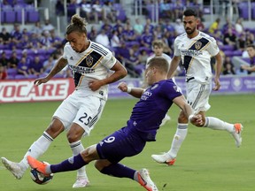 Orlando City's Chris Mueller (9) takes a shot against LA Galaxy's Rolf Feltscher (25) during the first half of an MLS soccer match Friday, May 24, 2019, in Orlando, Fla.