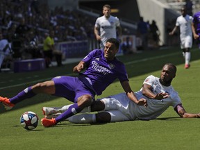 Orlando City's Tesho Akindele, left, and FC Cincinnati's Kendall Waston battle for possession of the ball during the first half of an MLS soccer match, Sunday, May 19, 2019, in Orlando, Fla.