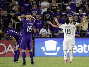 LA Galaxy's Uriel Antuna (18) celebrates with Efrain Alvarez as Orlando City's Kyle Smith, left, and Sacha Kljestan (16) react at the end of an MLS soccer match Friday, May 24, 2019, in Orlando, Fla. The Galaxy won 1-0.