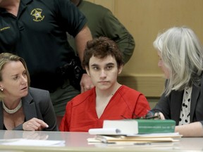 Parkland school shooting suspect Nikolas Cruz in court at the Broward Courthouse in Fort Lauderdale, Fla., Tuesday, May 1, 2019 for motion by the Public Defender's Office to withdraw from the case due to Cruz receiving an inheritance that can be used to pay for a private attorney. Defense attorney Melisa McNeill and Diane Cuddihy speak with their client. Nikolas Cruz, who faces the death penalty if convicted. Cruz is accused of killing 17 and wounding 17 in the February 2018 mass shooting at Marjory Stoneman Douglas High School in Parkland, Fla.