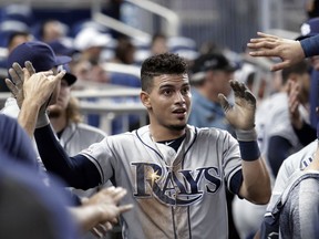 Tampa Bay Rays' Willy Adames is congratulated in the dugout after scoring on a double by Anthony Bemboom in the second inning during a baseball game against the Miami Marlins, Wednesday, May 15, 2019, in Miami.