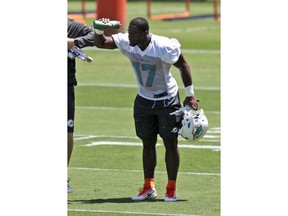 Miami Dolphins running back Mark Walton (17) sprays his face with water during NFL football rookie minicamp, Saturday, May 11, 2019, in Davie, Fla.