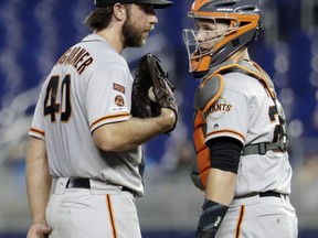 San Francisco Giants starting pitcher Madison Bumgarner (40) talks with catcher Buster Posey during the third inning of the team's baseball game against the Miami Marlins, Wednesday, May 29, 2019, in Miami.