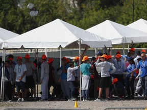 FILE - In this Monday, May 6, 2019 file photo, migrant children stand outside the Homestead Temporary Shelter for Unaccompanied Children in Homestead, Fla. The U.S. government is providing long-distance video counseling to teens housed at the country's largest migrant detention center as officials struggle to accommodate increasing numbers of minors illegally crossing the U.S.-Mexico border. Some mental health experts and human rights advocates say that may not be the best way to help young people coping with trauma.